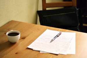 Papers and pen on table at a coffee shop for in person tutoring